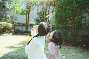 シャボン玉で遊ぶ姉妹