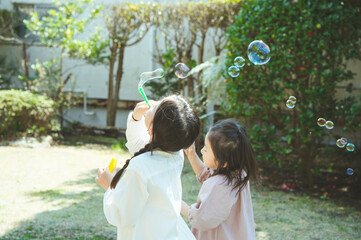 シャボン玉で遊ぶ姉妹
