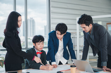 Group of young business people sit at their desks with smiling colleagues together in the office.  Meeting business people  planning concept, laptop meeting ideas. Concentrate on work. LGBT teamwork.