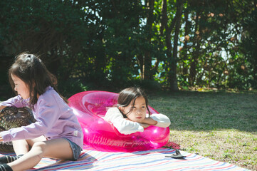 庭でうきわで遊ぶ姉妹