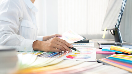 creative graphic designer choosing color scale for editing artwork while working in office.