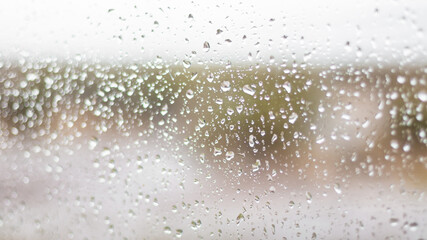 Gotas de lluvia sobre vidrio vista desde interior hacia campo abierto en la patagonia argentina