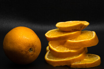 knife cutting orange in detail with black background, orange concept