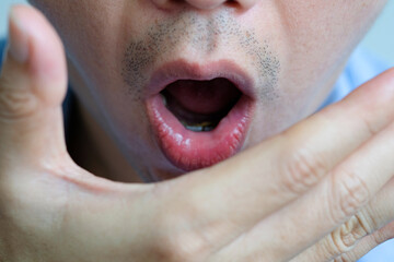 Oral health Men use hands to check for bad breath and breathe.