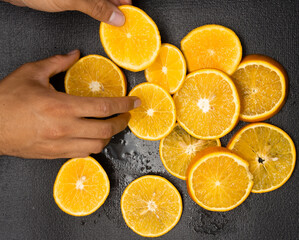 knife cutting orange in detail with black background, orange concept