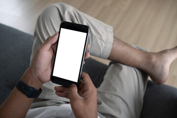 Close up view of casual man sitting on sofa and using smart phone.
