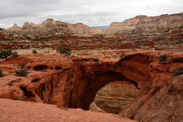looking through cassidy's arch at the incredible eroded rock formations on a cloudy fall day  in capitol reef national park, utah