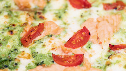 pizza with salmon, broccoli, tomatoes, cream cheese and mozzarella cheese, close up