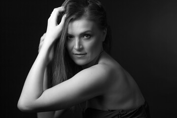 black and white portrait of an adult woman in a studio on a black background.