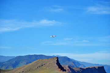 Airplane in the sky over the mountains