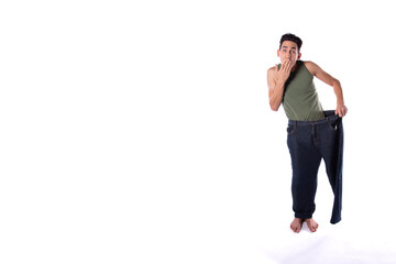 Funny young guy in big pants. Diet and weight loss. The result of fitness and training. White background. Isolate.
