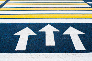 Yellow and white pedestrian crossing marking on the road. Urban photography. Sign. Directional...