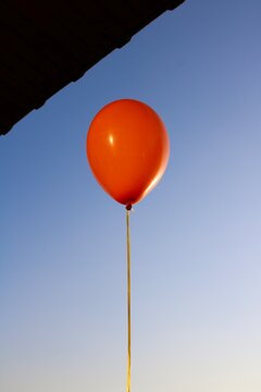Low Angle View Of Red Balloon Against Clear Blue Sky