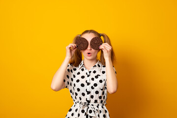 Full of sweet chocolate flavors. Cute girl having fun with cookies. Pretty girl covering eyes with cookies. Bakery style chocolate chip cookie recipe. Bakery shop. Following a cooking recipe.