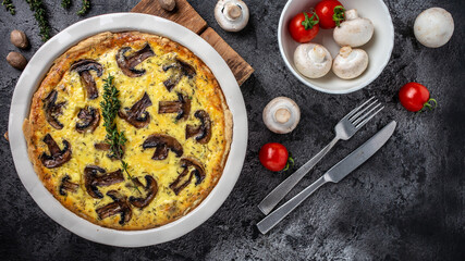 Traditional french pie Quiche Lorraine with mushrooms, cheese and seasonings in baking dish. banner, menu recipe place for text, top view