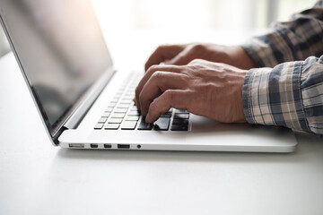 Side view shot of businessman working with mock up computer laptop working at office