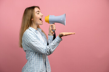 Funny young blonde woman girl posing isolated on pastel pink wall background studio portrait. People sincere emotions lifestyle concept. Mock up copy space. Screaming in megaphone
