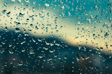Rain drops on window glasses surface with sunset. drops on glass spray on window background for...