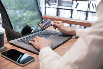 Woman holding credit card and using laptop computer. Online shopping concept.