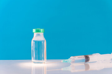 Potential trials stage concept on blue background. Close up Vials with sterile needle syringe. Research and Development, Vaccination.