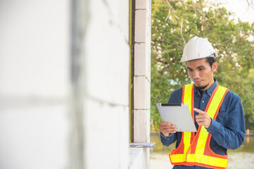 Foreman checking house in construction site by tablet technology