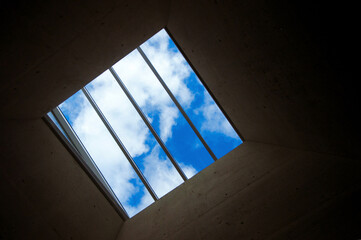 Obraz premium Prison window with grille overlooking beautiful blue sky with clouds