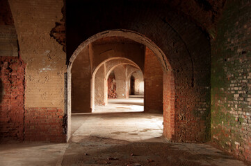 Fototapeta na wymiar Perspective view of dark tunnel with an arched brick ceiling in old abandoned