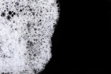 White soap sud isolated on black background.