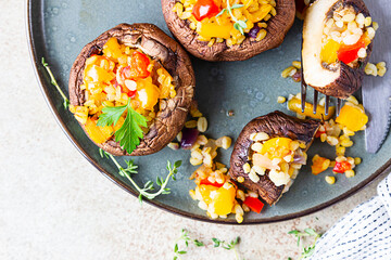 Baked stuffed portobello mushrooms with bulgur pilaf and chopped vegetables. Delicious and nutritious vegetarian dish.