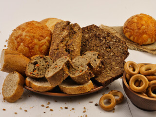 Rye baguette, rolls with cheese and dryingcookies on a plate