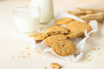 Healthy oatmeal or multigrain cookies with seeds and nuts on baking paper, light concrete background.