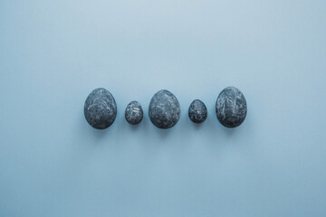 5 blue gray marble painted Easter eggs on a blue background