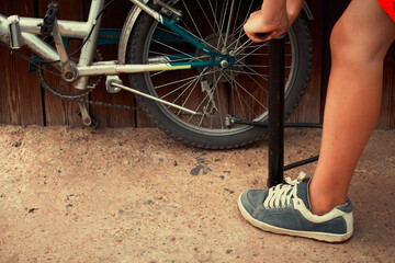 Naklejka premium Teenager pumping up tires of bike.