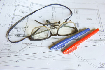 Glasses with red and blue pen to mark up architectural drawing