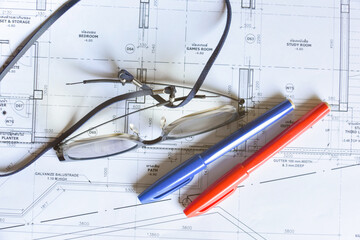 Glasses with red and blue pen to mark up architectural drawing