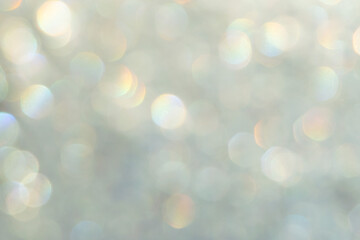 bright glitter background: bokeh effect from many colored lights on frozen glass, toning