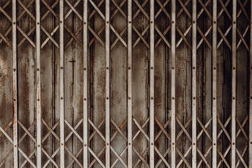 Old grunge rusty shutter folding door for shop closed or business down concept, texture pattern or...