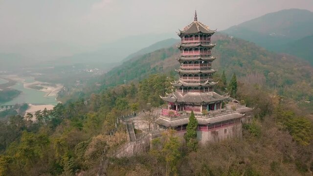 Aerial drone point of view of Dujiangyan, Chengdu, Sichuan, China. Mountain Qingcheng in the summer morning. Spin around up behind the woods mountain with pagoda tower on the hill top. Worship place