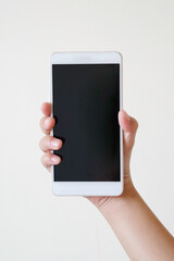 Business concept : Young man holding smartphone with blank screen on white background, closeup of hand, advertising text selling marketing products, mock up, Space for text.