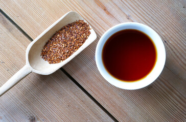 Red bush rooibos loose tea on wooden shovel scoop and cup africa natural product