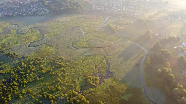 4k drone flight moving to the side footage (Ultra High Definition) of flooded valley. Misty morning scene of snake shape Seret river. Wonderful sunrise on Ternopil countryside, Ukraine, Europe.