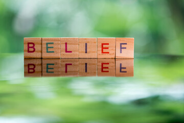 Words concept, BELIEF word cube on reflection floor bokeh blur background ,English language learning concept.