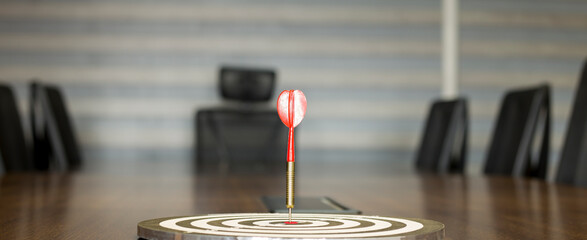 The dart board has an arrow thrown into the center of the shooting target for business targeting.