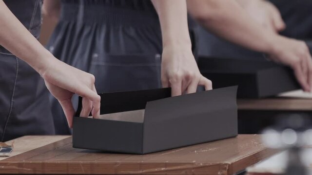 Worker hands laminated cardboard box. Modern factory of production cardboard box. Manufacture of cardboard boxes from paper. Enterprise for production package. Paper corrugated box factory.