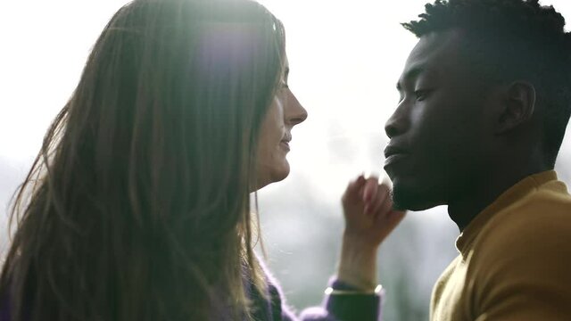 Young interracial couple kissing outside. Black man with white girlfriend kiss, diversity concept