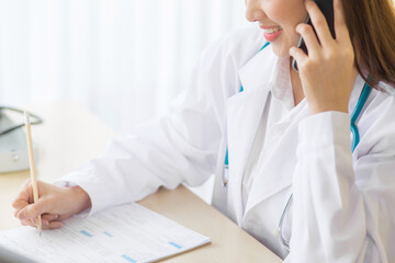 Asian female doctors provide telephone counseling in  health care,new normal and coronavirus protection concept.