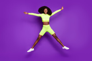 Fototapeta na wymiar Photo of excited crazy lady jump open mouth wear green shirt shorts footwear isolated violet background