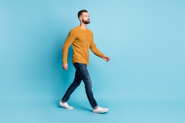 Fototapeta na wymiar Full size photo of young serious cool attractive handsome man go walk look copyspace isolated on blue color background