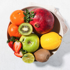 Flatlay assorted fresh and ripe fruits and berries on a plate. The concept of healthy eating.
