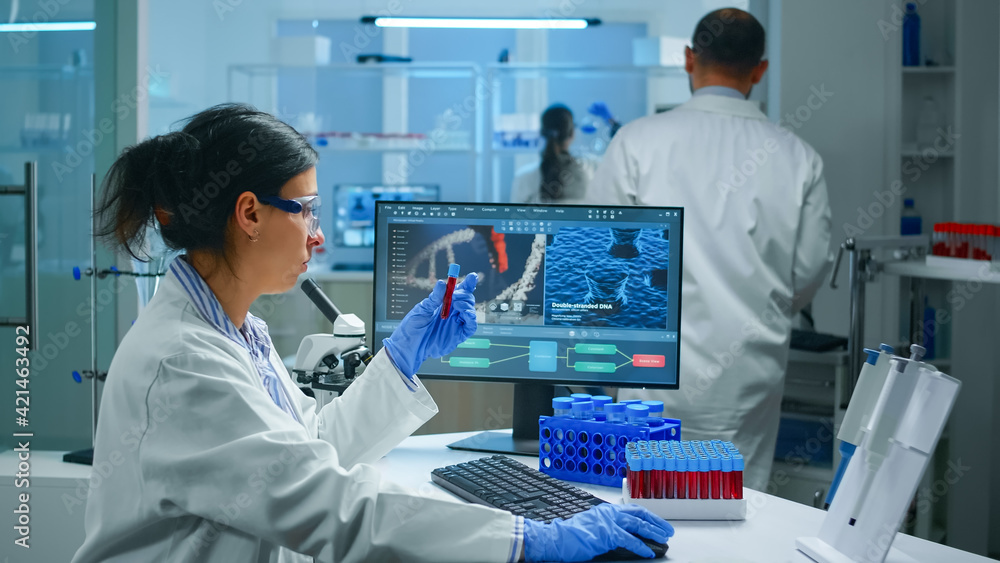 Poster group of scientists wearing lab coat working in laboratory while examining biochemistry sample in te